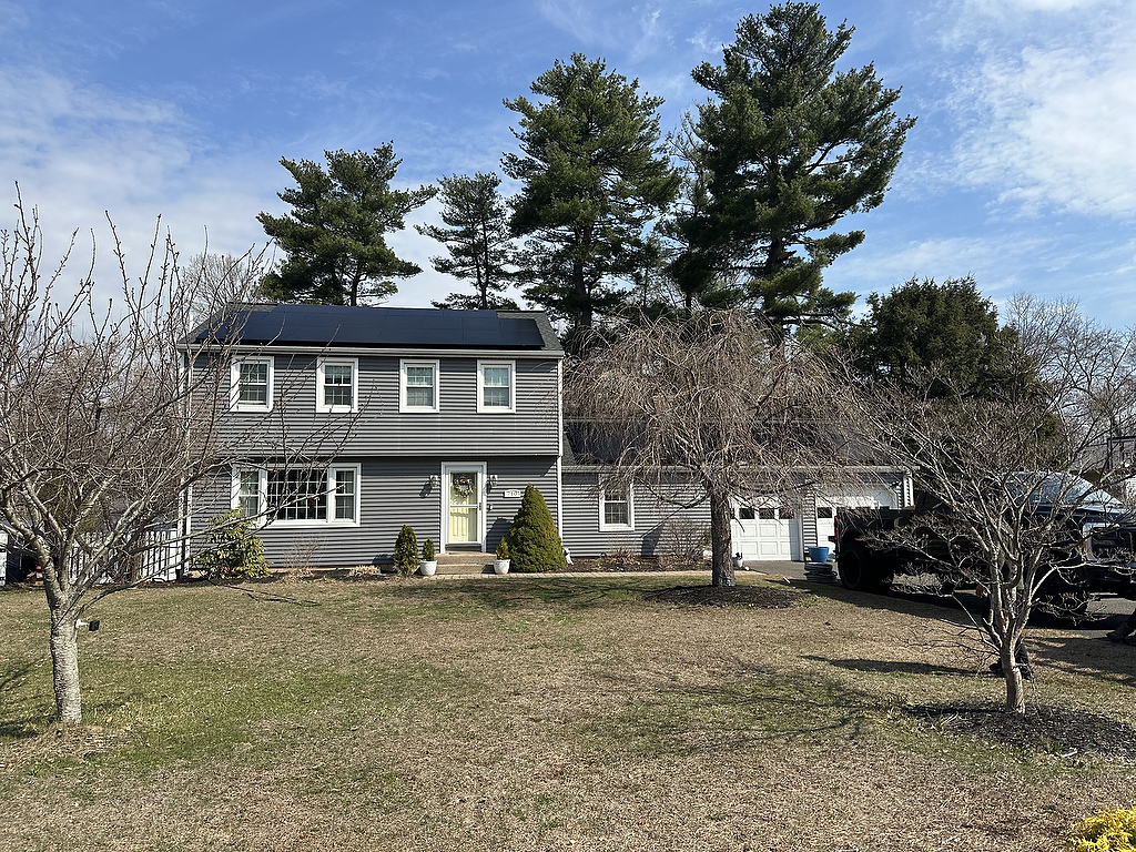 Solar installation on colonial home with trees