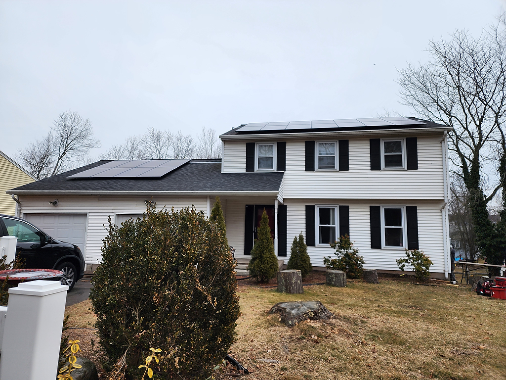 Solar panels on colonial home with black shutters